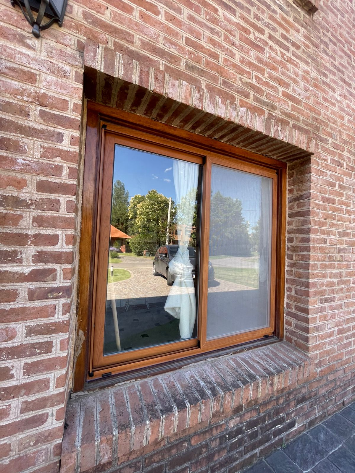 Ventana de PVC efecto madera en fachada de ladrillos — Pilar, Zona Norte